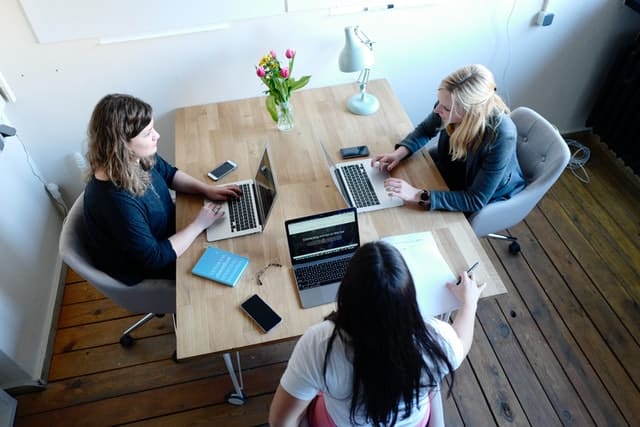 Colleagues sitting at a table working on leading a project