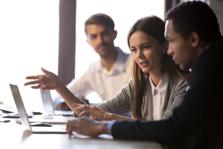 Two coworkers planning their project communications plan on their computer