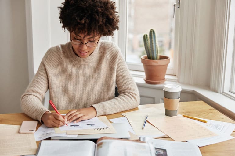 Woman at her desk working on PMP exam