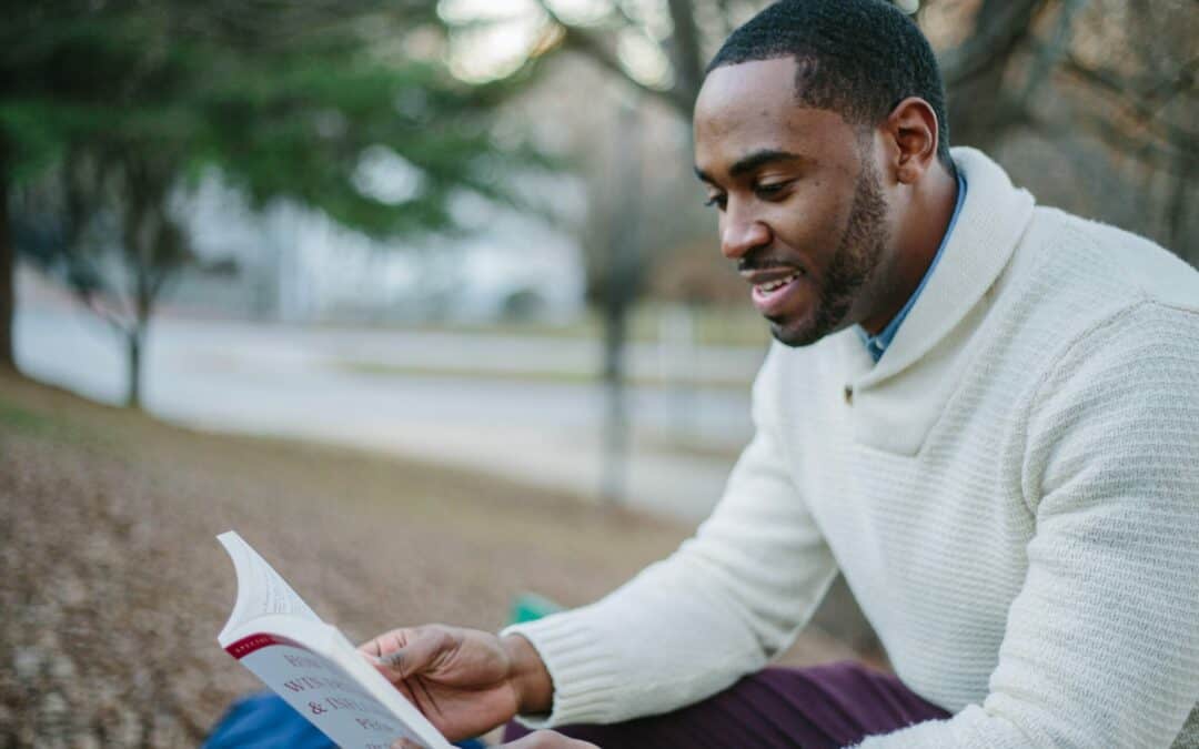 African American man outside reading a book