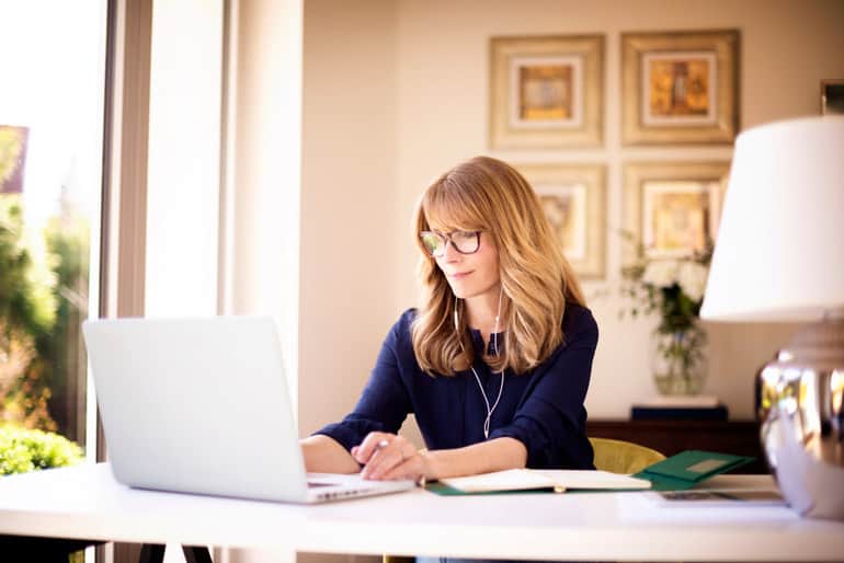 Woman at home office reading about PMI-PBA