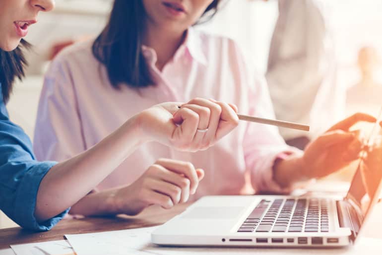 Two business women working on agile requirements on computer