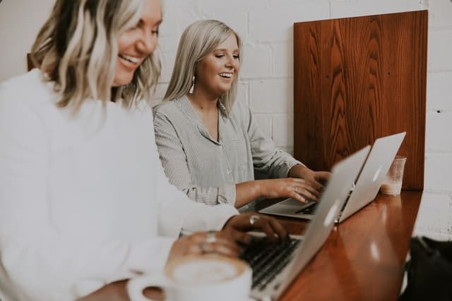 A business analyst working along side a colleague at their computers