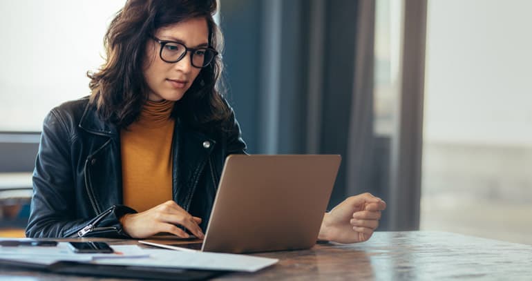 Woman using her computer to read about the PMI-ACP exam