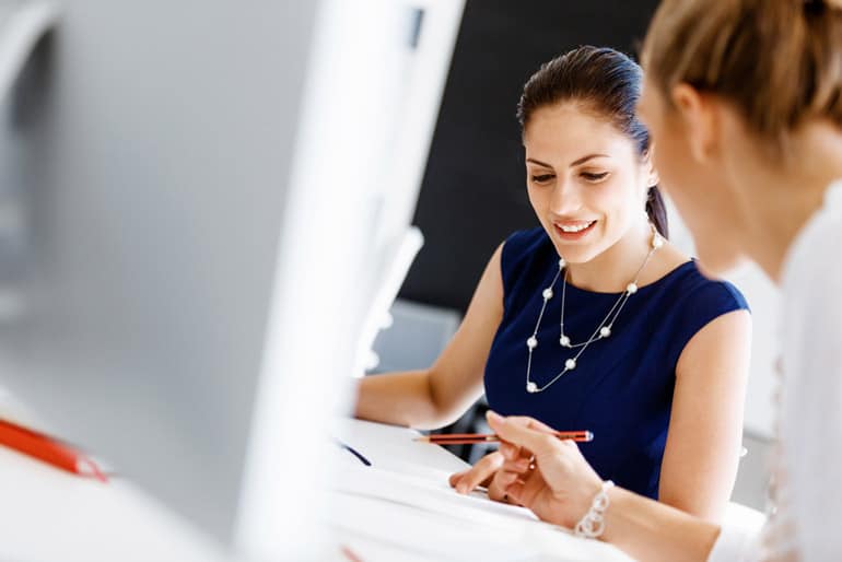 Business woman discussing a project with a colleague at a desk