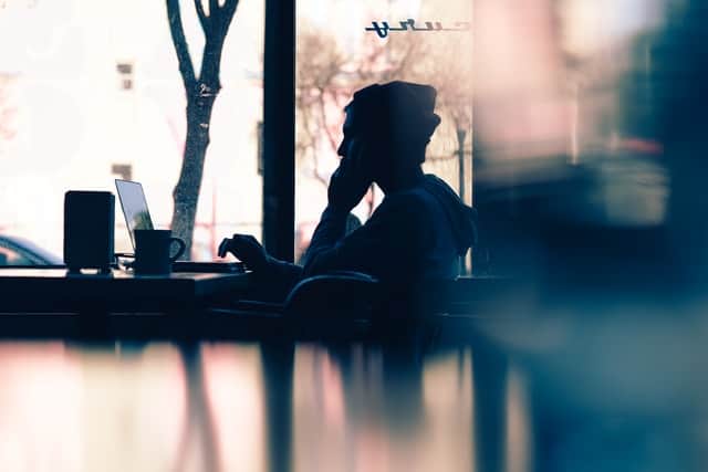 Young person having coffee working at computer