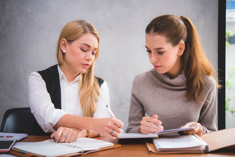 Two project managers at table discussing a project