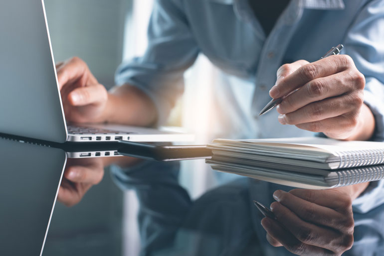 Close up of business person working at computer on project goals