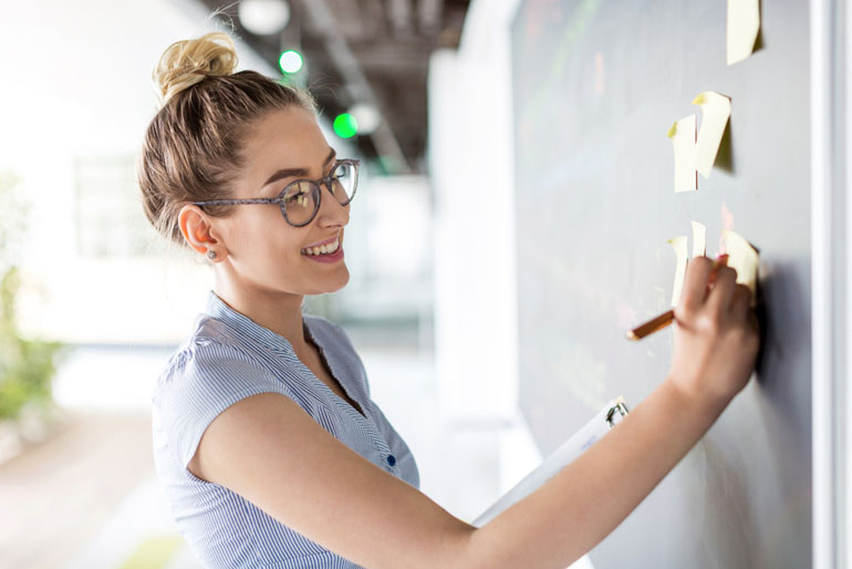 Woman at white board working on agile implementation