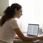 Woman gathering information about the PMP exam 2023 at her desk on her computer